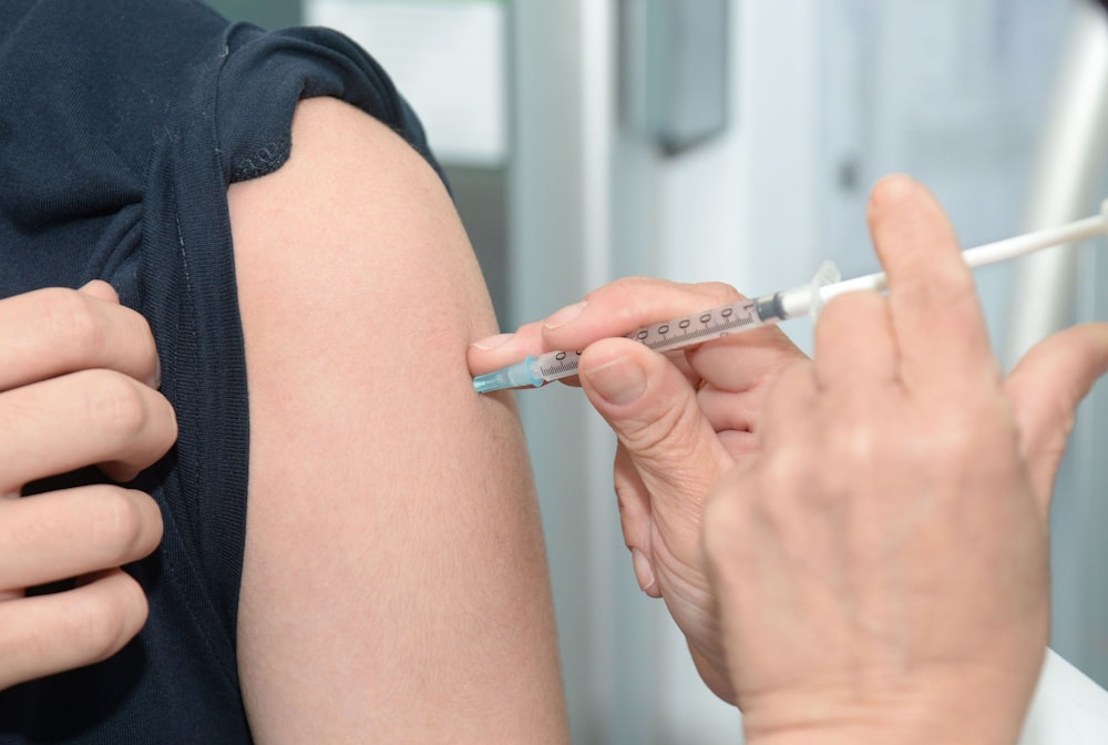 person injecting someone on his arm