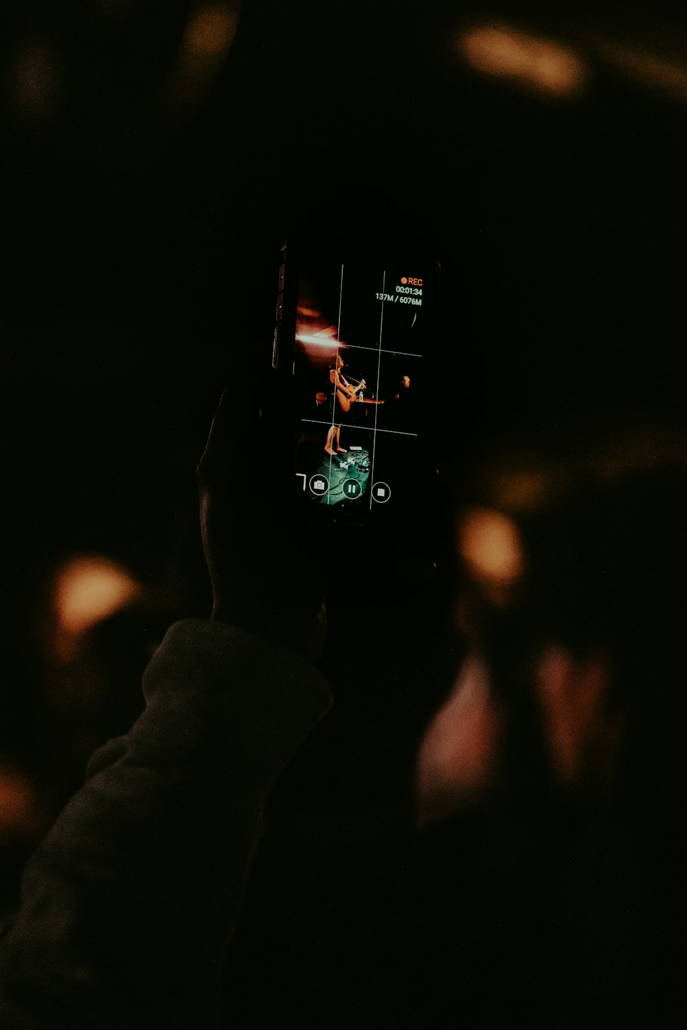 a person holding up a cell phone in the dark