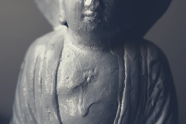 Close-up of a handcrafted cement statue with textured details in natural light