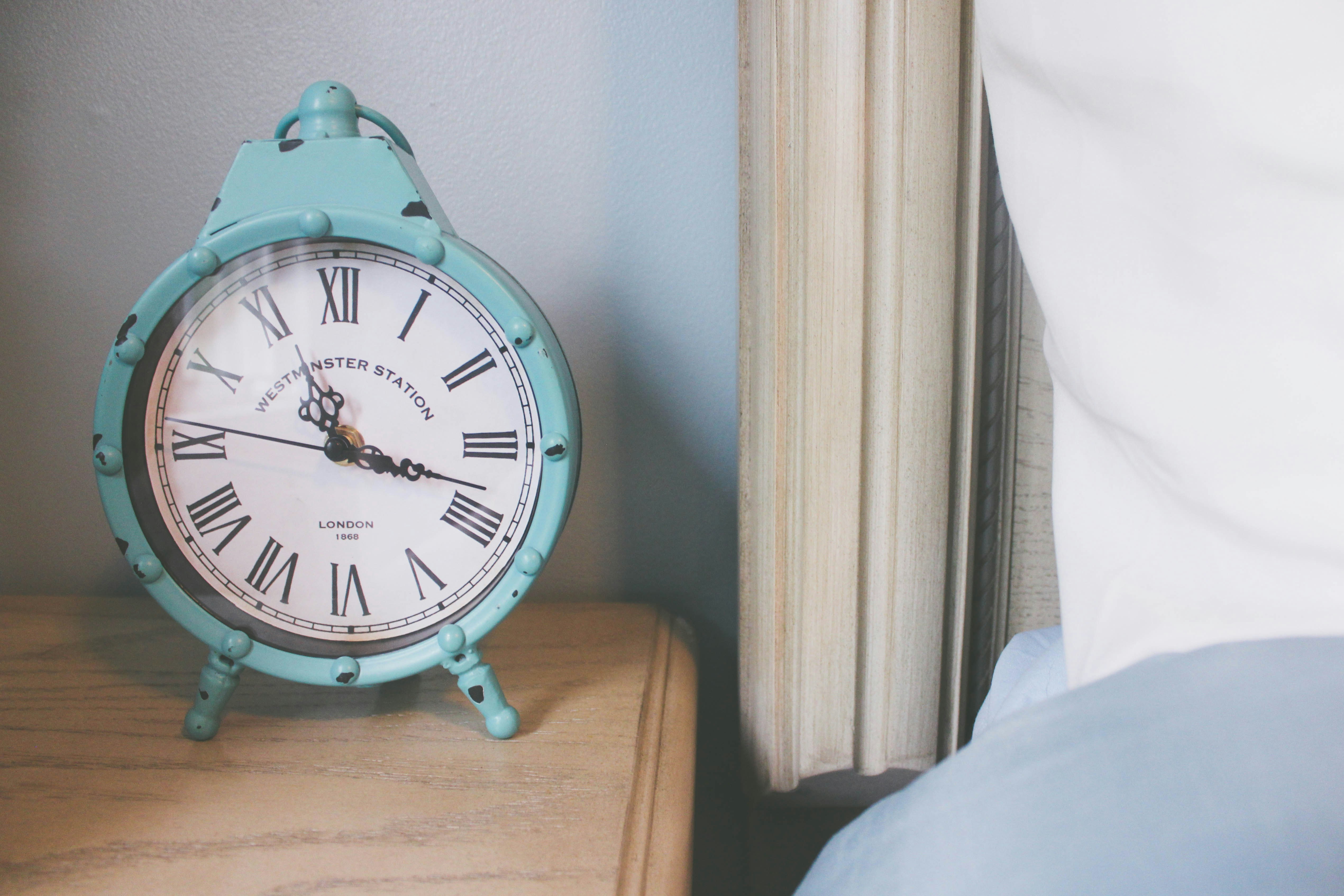 Alarm clock on a nightstand representing sleep timing and duration