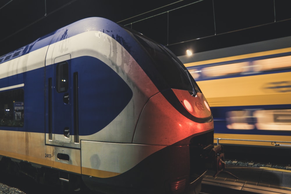 white and blue train near another train