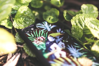 A close-up of a colorful floral phone case resting on a wooden table.