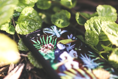 A close-up of a colorful floral phone case resting on a wooden table.