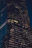 A stylish multi-story building with glass facades illuminated at night in a cityscape.