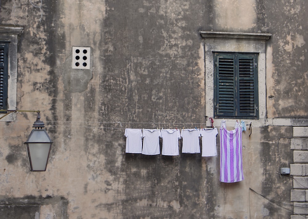 clothes hanged on wire beside window