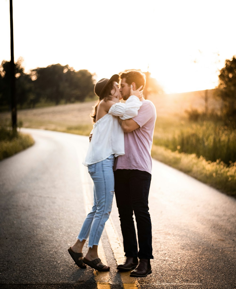 man and woman kissing each other on road