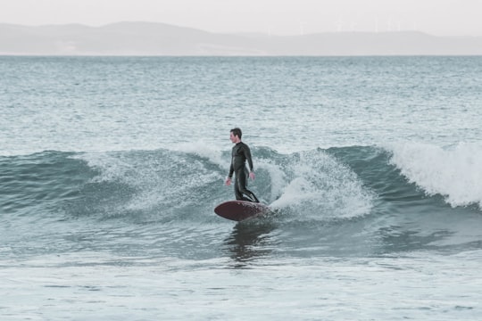 man in black wet suit surfing in Jeffreys Bay South Africa