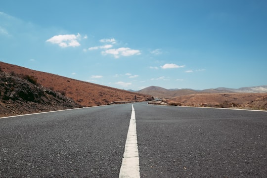 empty road between brown grasses in Fuerteventura Spain