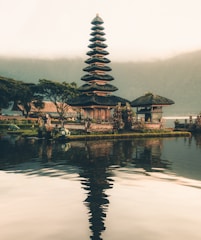 temple beside body of water and trees