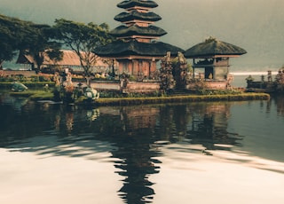 temple beside body of water and trees