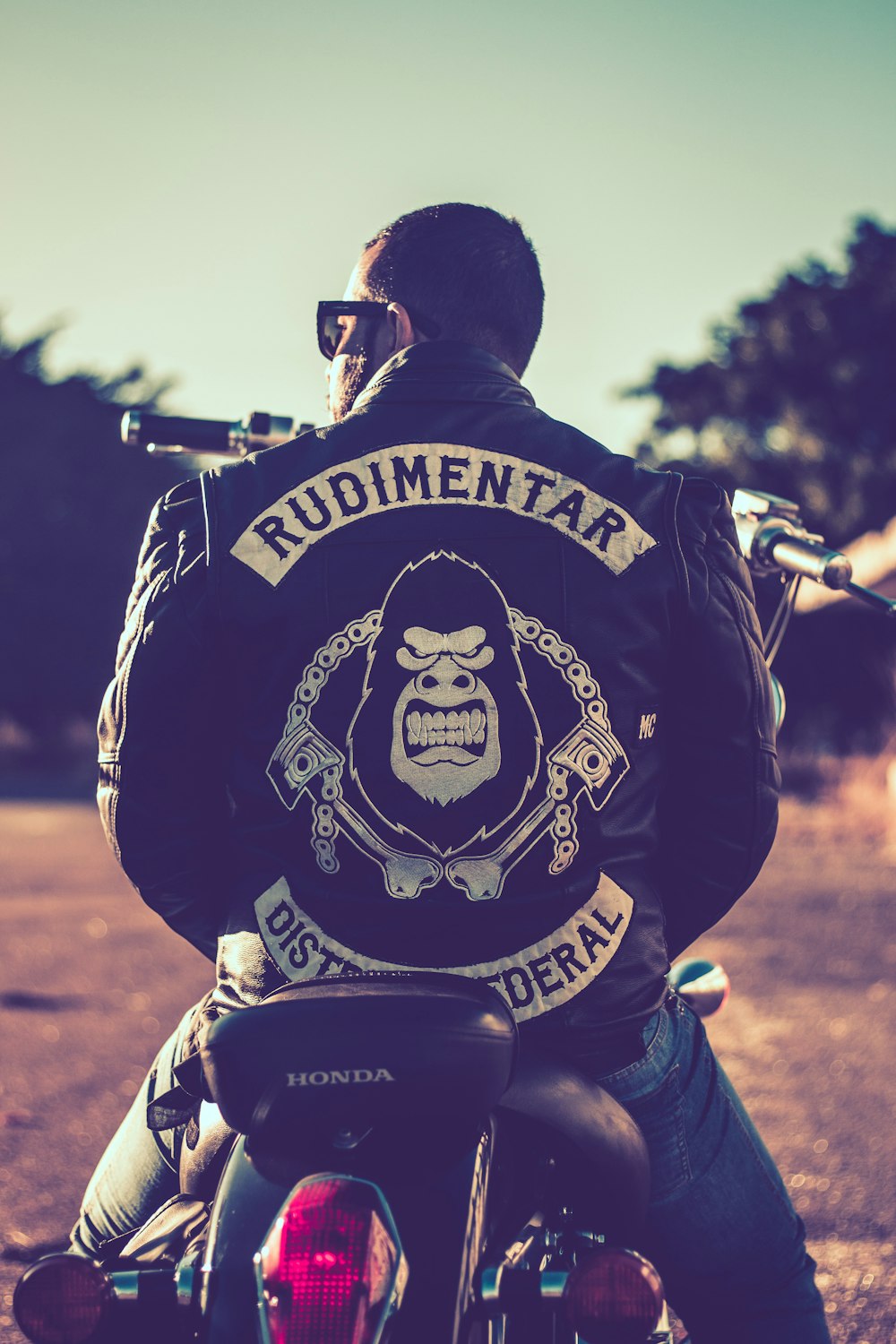 man wearing black jacket sitting on the motorcycle
