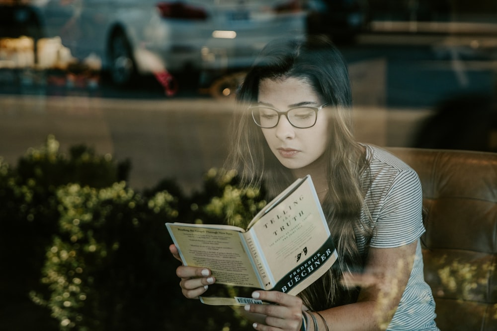 Mujer con gafas de montura negra libro de lectura