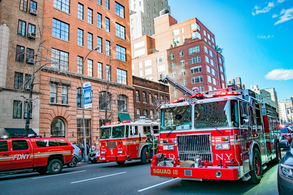 two firetrucks near brown concrete buildings during daytime
