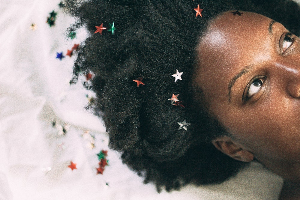 woman lying on white mat with stars on hair