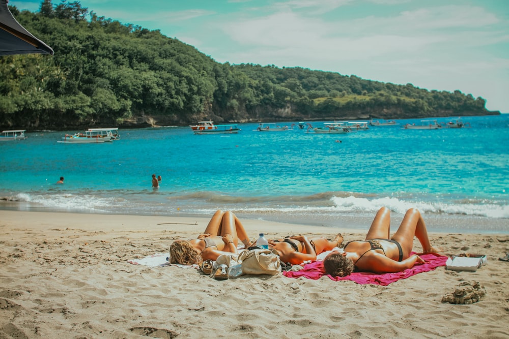 women sun bathing in beach
