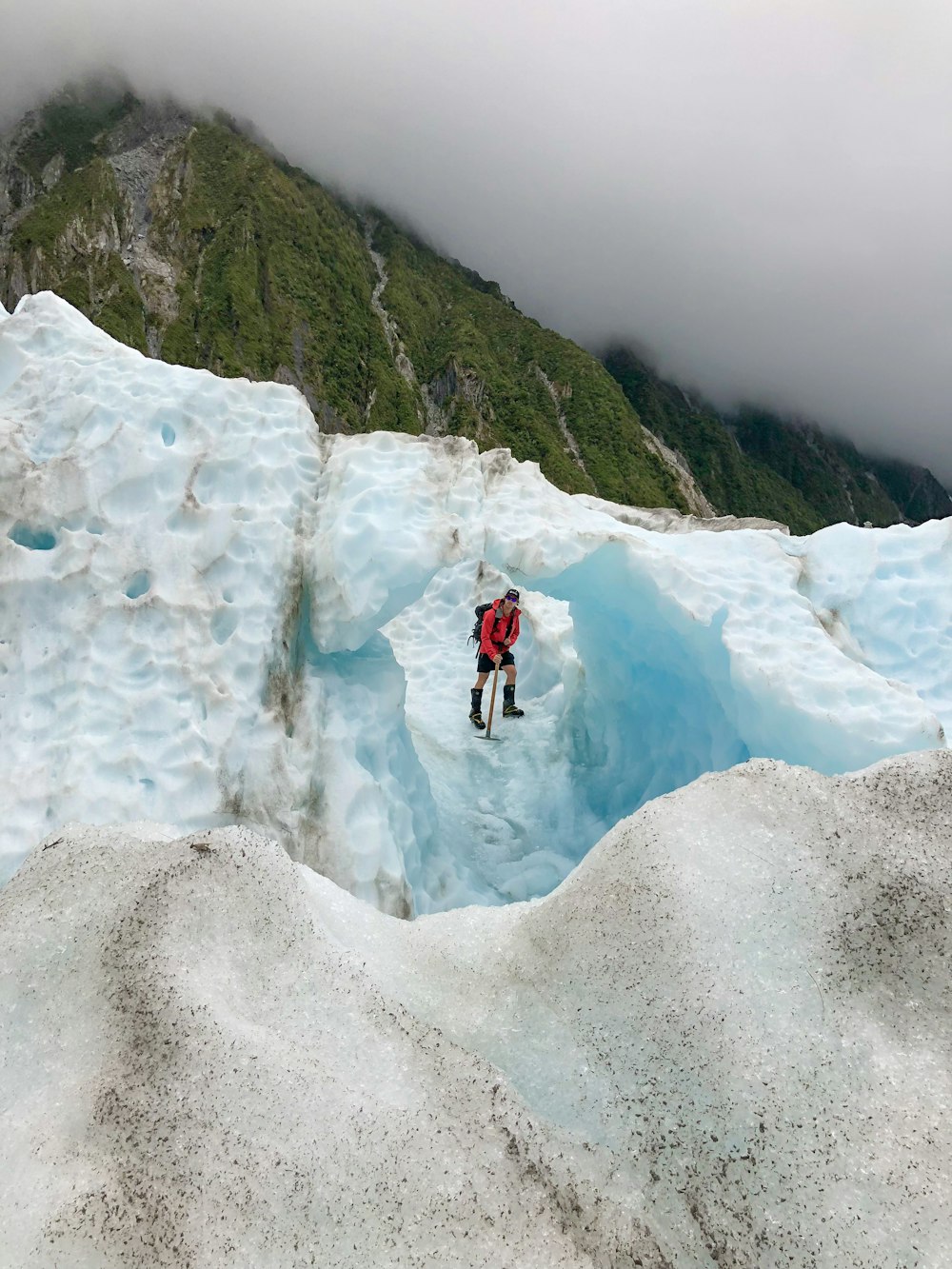 person standing on ice hill