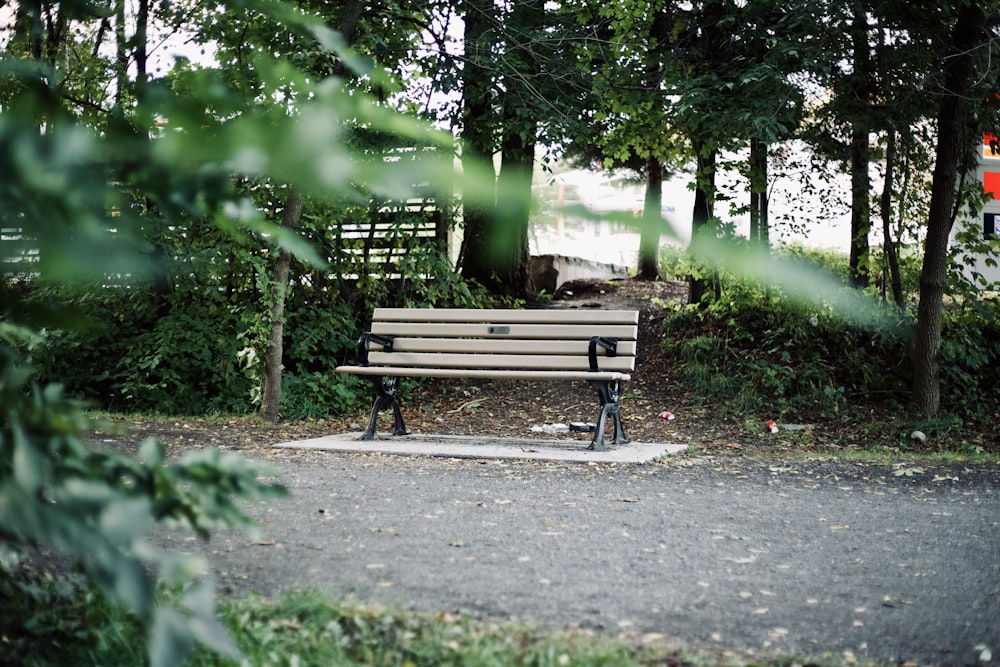 empty brown wooden bench beside footpath