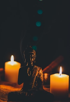 sitting buddha beside pillar candles