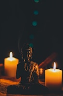 sitting buddha beside pillar candles