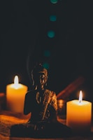 sitting buddha beside pillar candles
