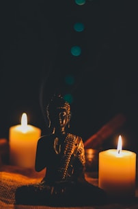sitting buddha beside pillar candles