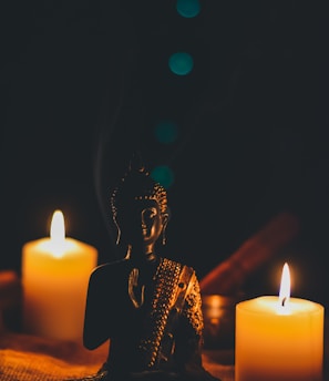 sitting buddha beside pillar candles