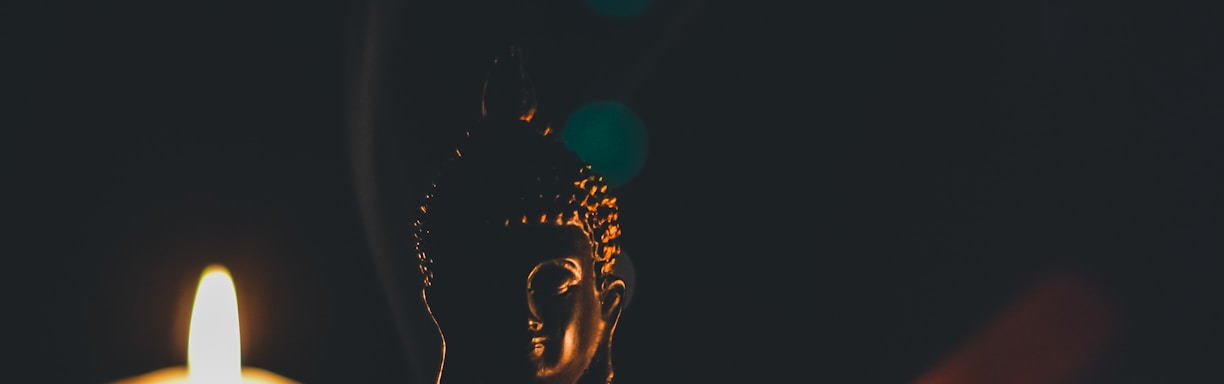 sitting buddha beside pillar candles