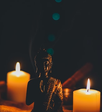 sitting buddha beside pillar candles