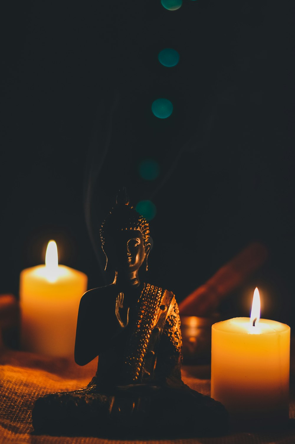 sitting buddha beside pillar candles