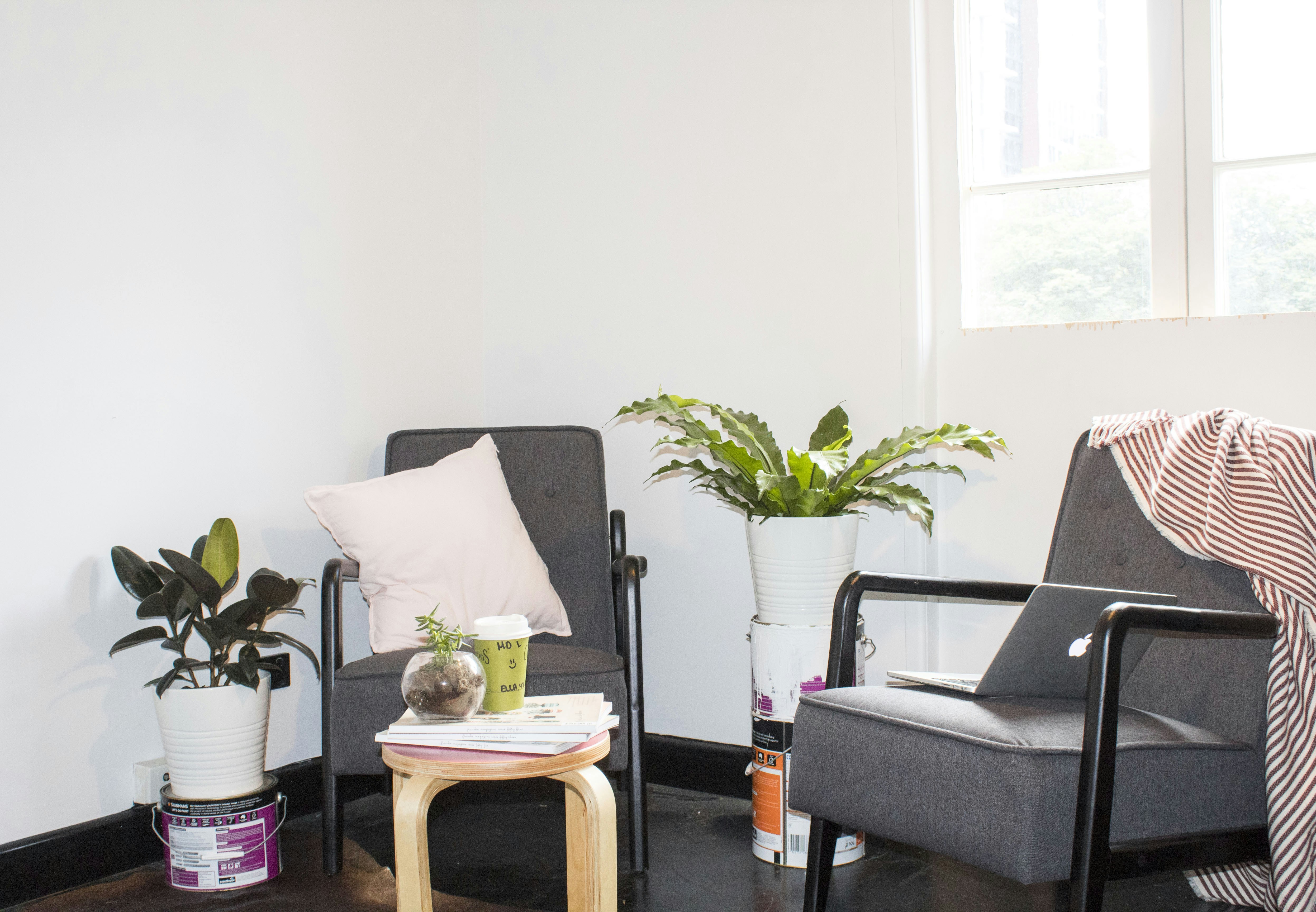 two black metal base padded armchairs near window