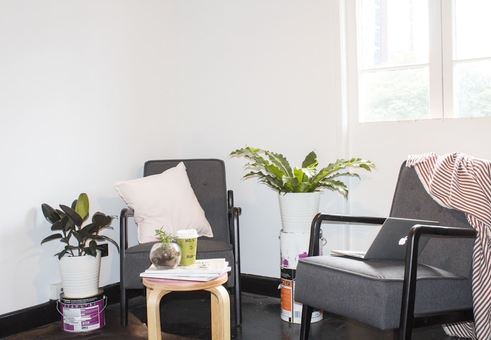 two black metal base padded armchairs near window