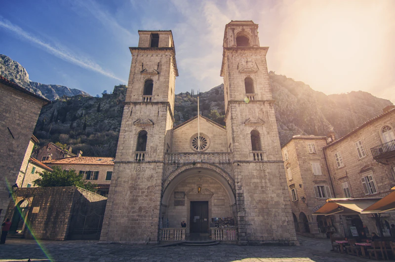 The twin Romanesque belltowers of St Tryphon Cathedral in Kotor against the mountainside