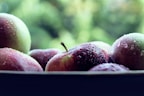A close-up of assorted organic fruits with water droplets glistening on them.