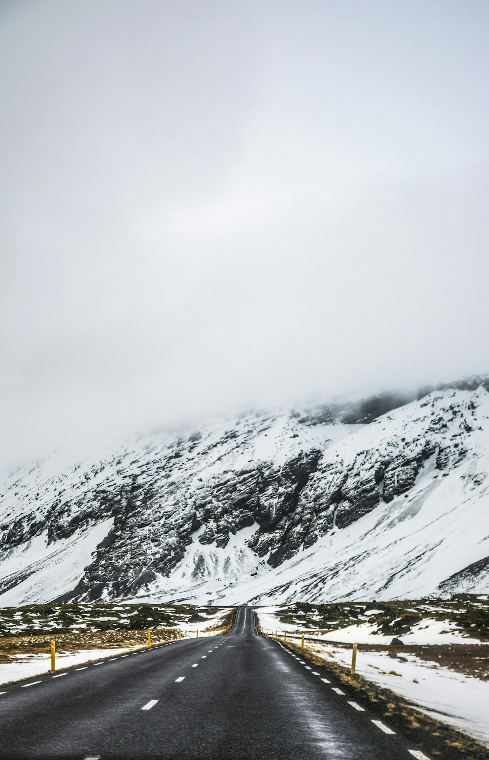 strada vuota accanto alla montagna innevata