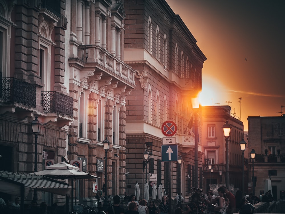 people on road beside buildings during golden hour