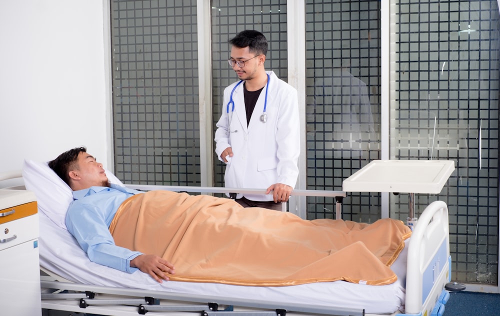 man lying on bed talking to doctor