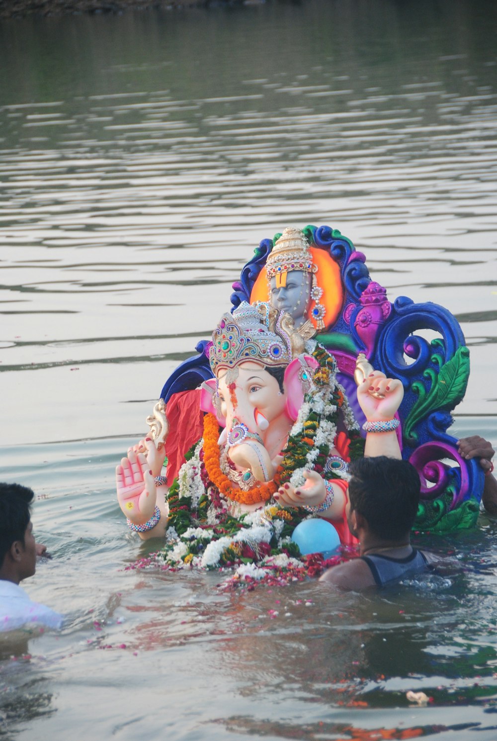 person holding hindu deity figurine