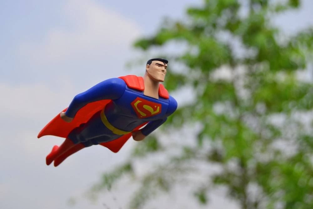 Superman fliegt in der Nähe von grünem Gras