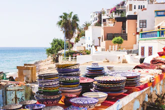 Colorful array of sunda bowls lined up on a wooden table by the shore.