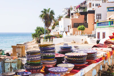 Colorful array of sunda bowls lined up on a wooden table by the shore.