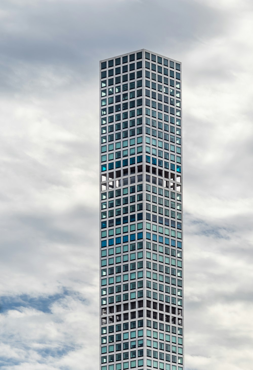 high-rise mirror building under white clouds