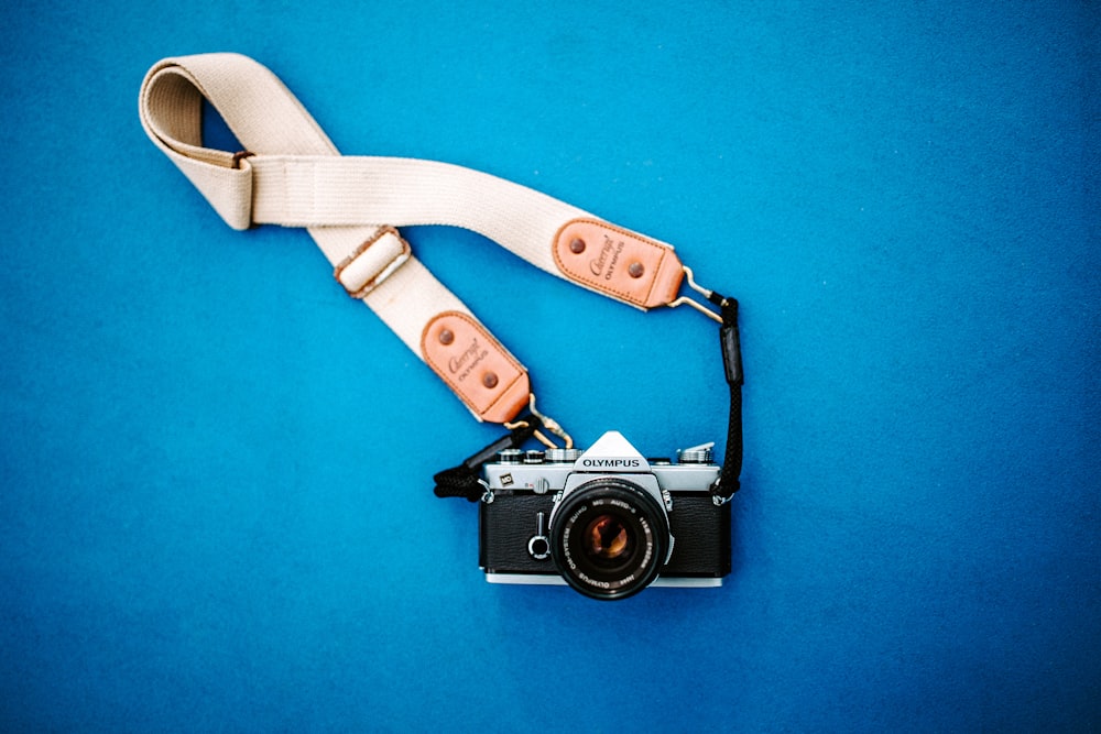 black SLR camera with white strap