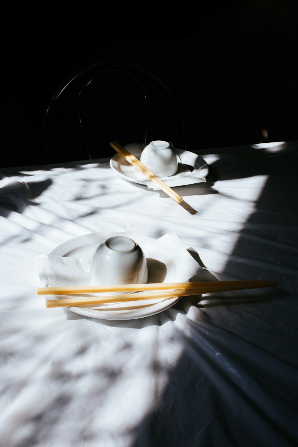 white ceramic teacup and saucer on white tablecloth