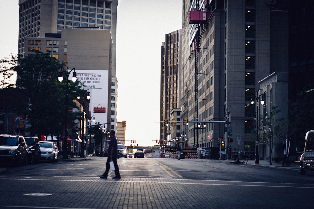 road between buildings and vehicles during sunset