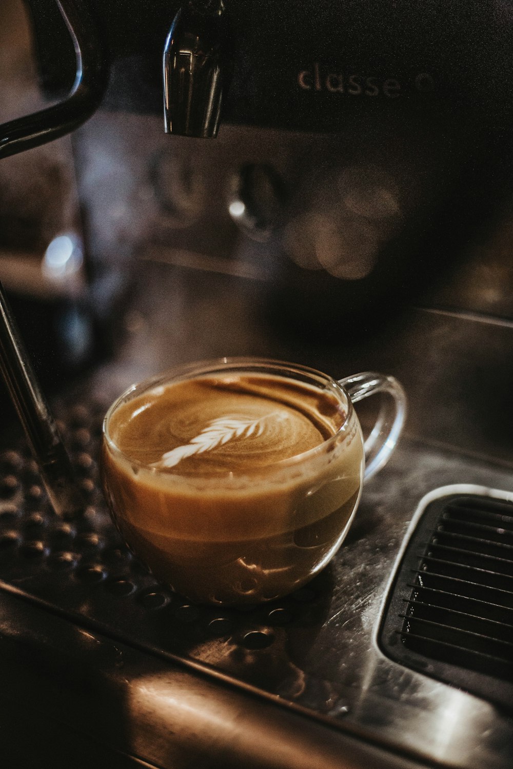 clear glass teacup with latte