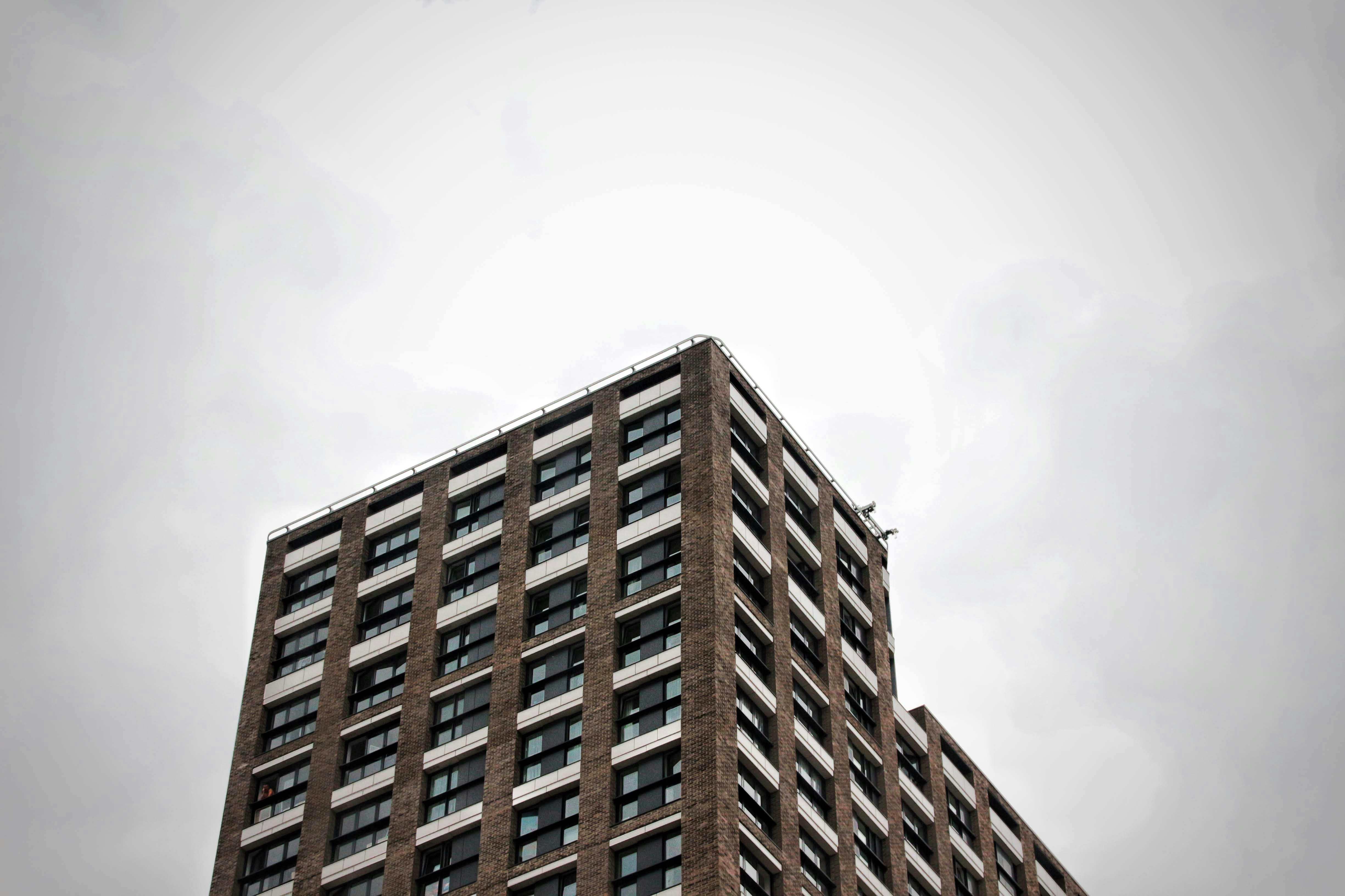 edificio in cemento marrone sotto il cielo bianco