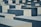 Large, rectangular concrete blocks of varying heights are arranged in a grid-like pattern. The blocks are shades of gray and are neatly aligned, creating a sense of uniformity and repetition.
