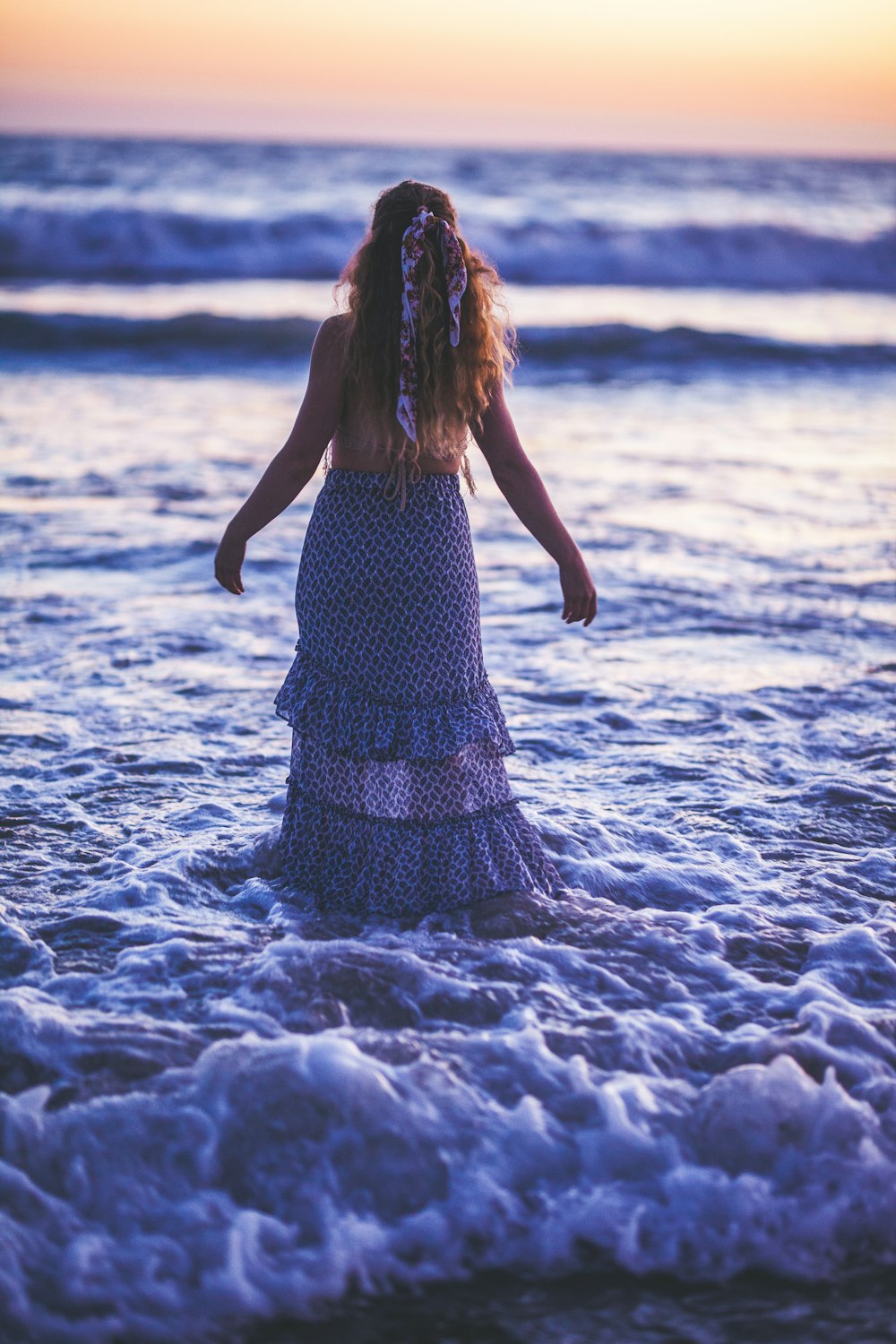 woman wearing dress walking on seashore