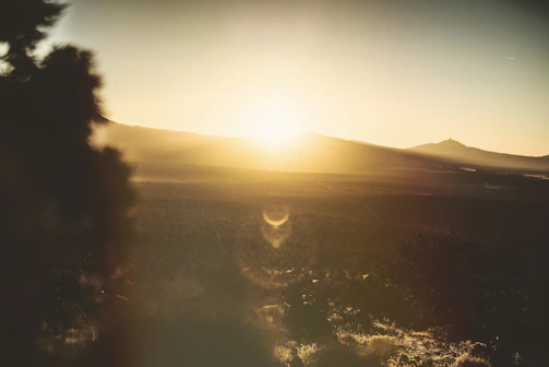 A panoramic view of continents from space during sunrise, casting warm light over the land.