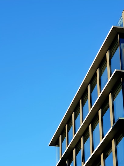 A sleek, modern commercial building exterior showcasing clean lines and minimalist design under a clear sky.